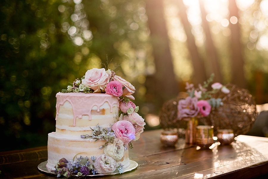 pink icing dripping on wedding cake with pink flowers 