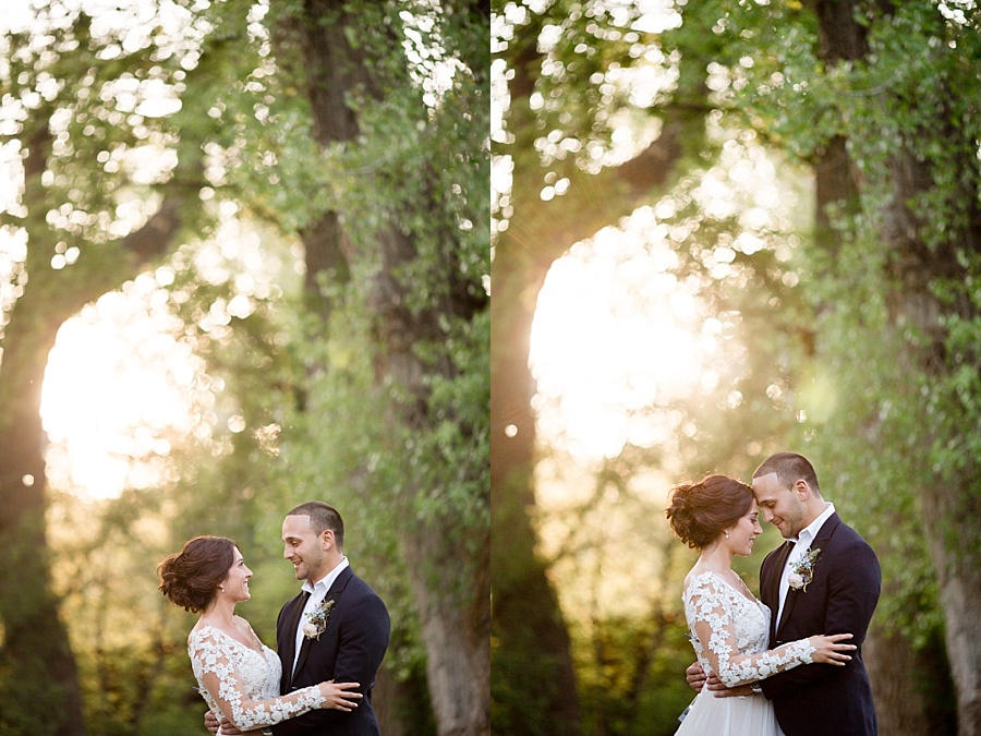 bride and groom pose in golden hour light in the woods 