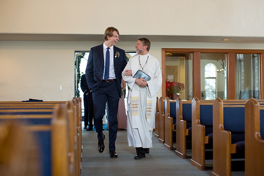 groom walks down the aisle with pastor at beaver creek chapel