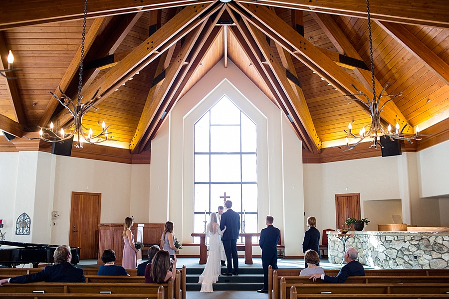 bride and groom stand together at the altar in beaver creek chapel