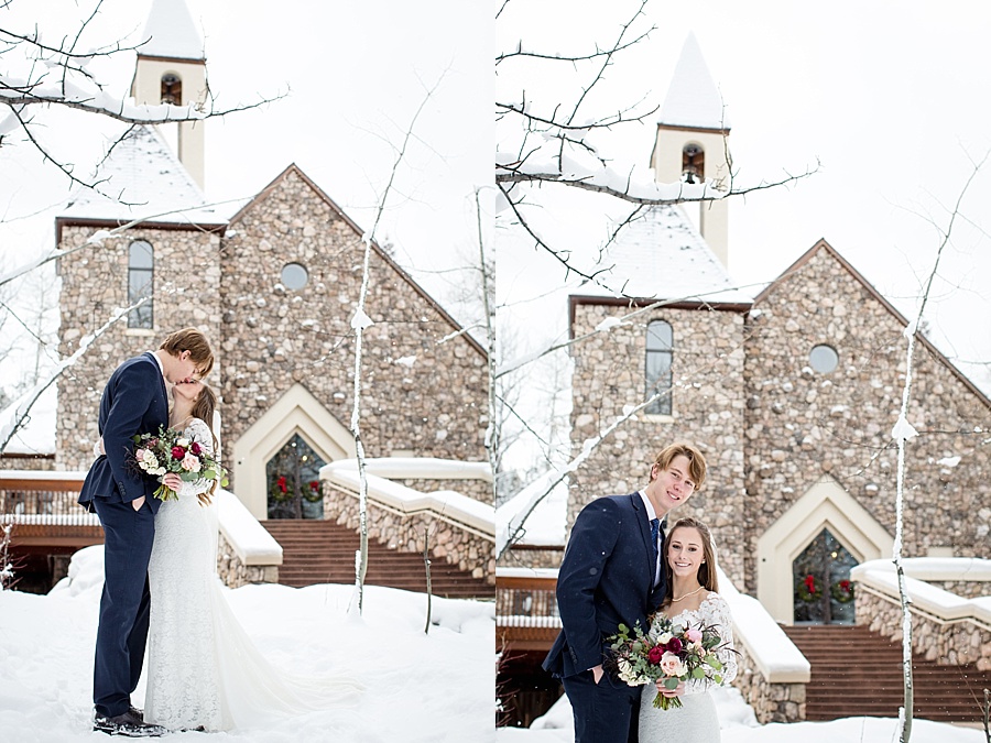 bride and groom pose in the snow in front of beaver creek chapel