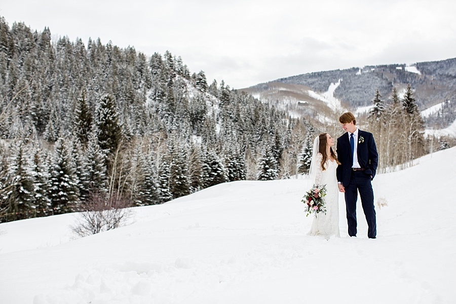 bride and groom look at each other lovingly in the snowy mountains in beaver creek