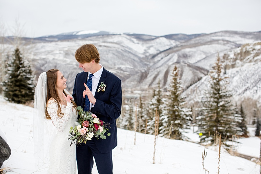 bride and groom look at each other with stunning snowy colorado mountain backdrop