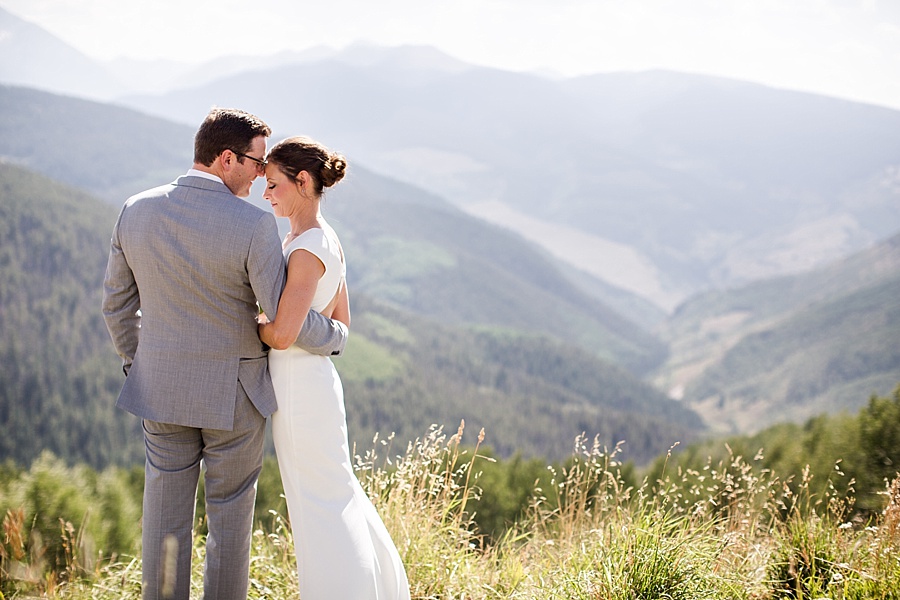 bride and groom touch heads at the top of a mountain in vail