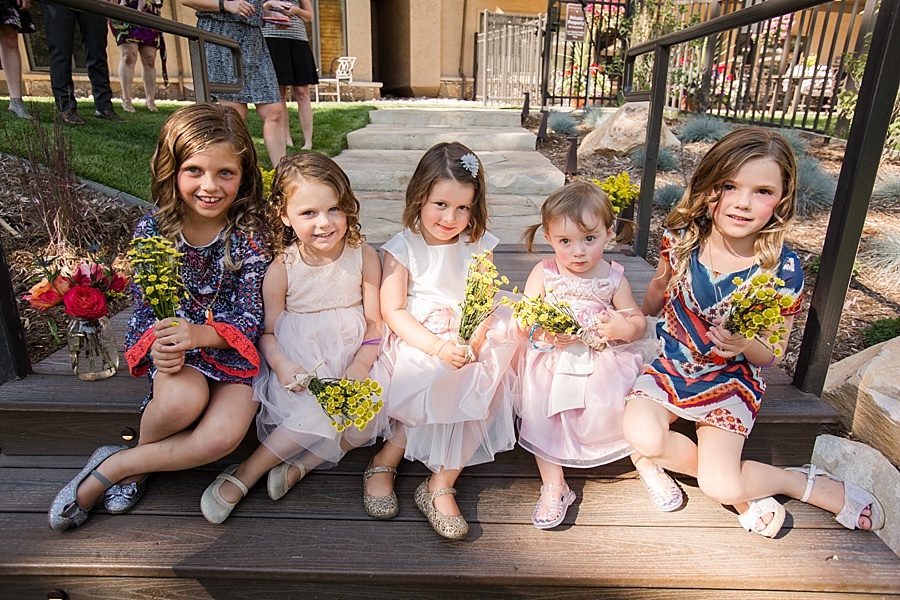 five flower girls pose with their flowers and mismatched dresses in vail colorado 