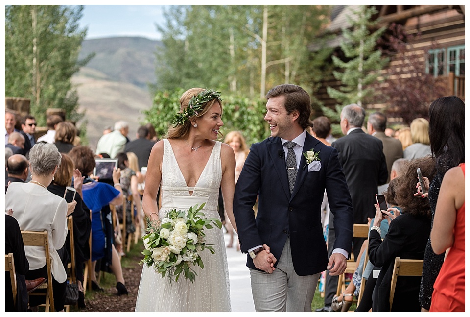 bride and groom look at each other as they exit the ceremony at ritz Carlton bachelor gulch