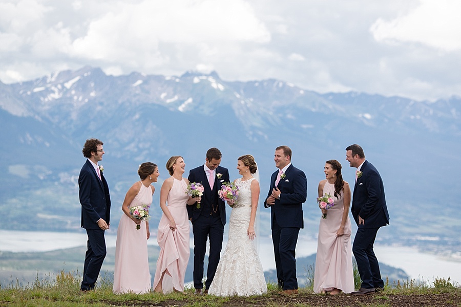 fun bridal party laughing together in front of stunning keystone mountain backdrop 