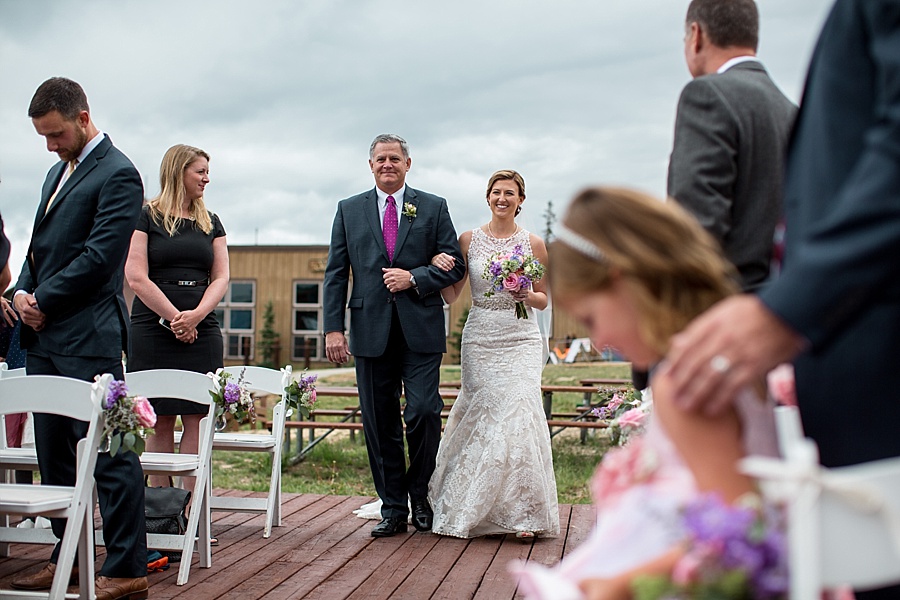 bride walks down the aisle with her father in keystone colorado 
