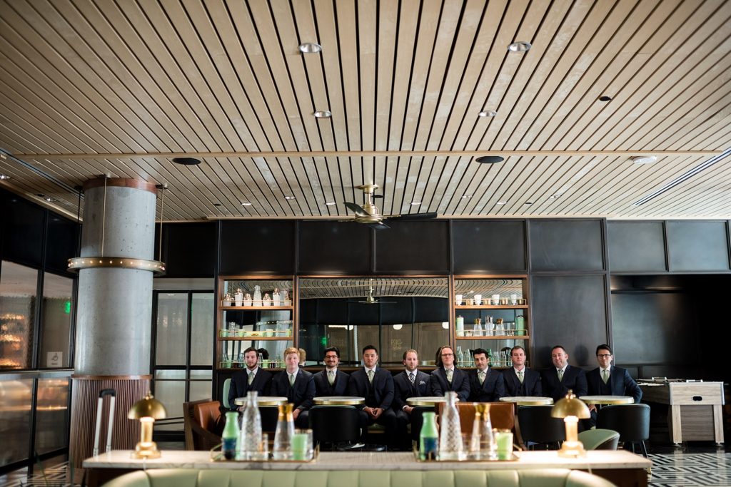 groom and groomsmen pose in modern room for portraits 