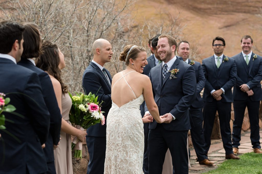 bride and groom laugh during wedding ceremony at red rocks trading post wedding 