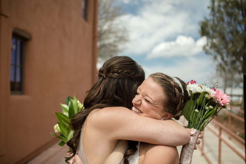 bride and her maid of honor hug after the wedding ceremony 
