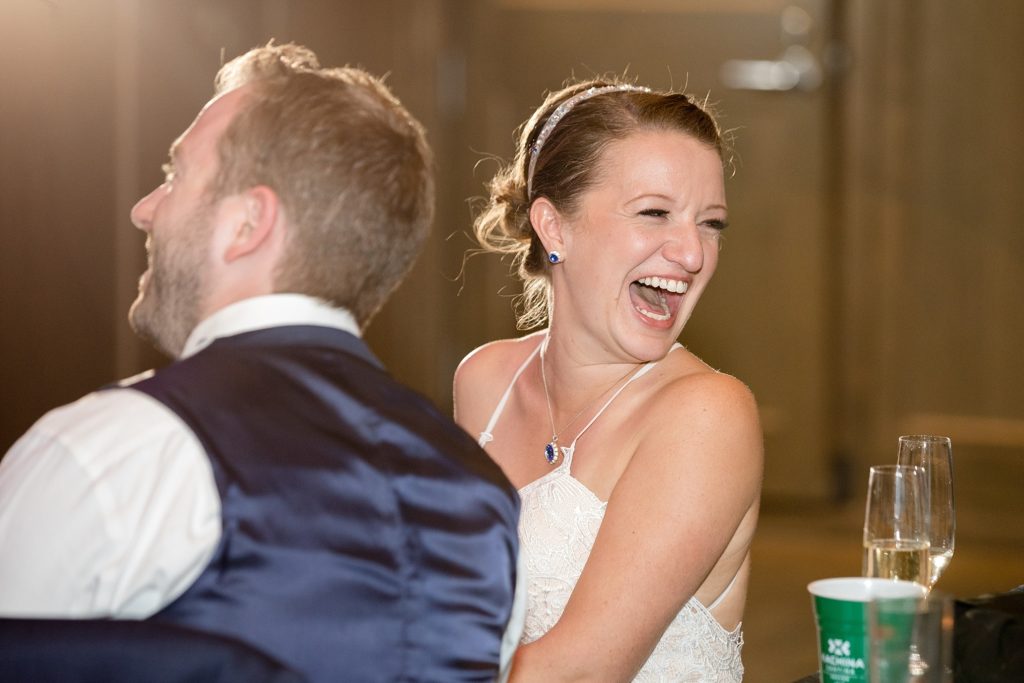 bride laughs during wedding reception toasts in denver colorado