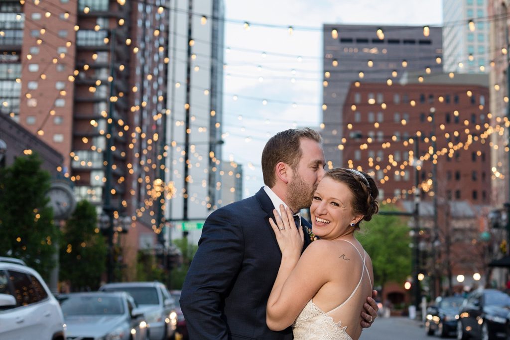 bride and groom pose for sunset photos in larimer square in denver with string lights 