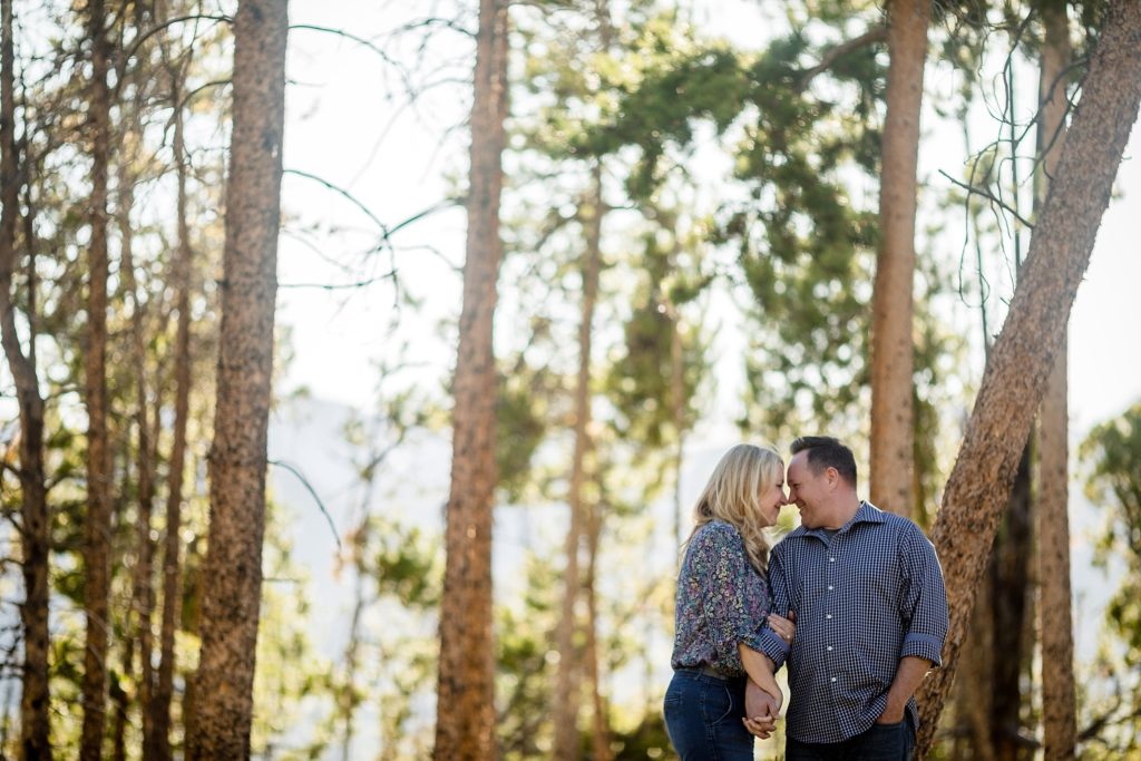 engaged couple posed with heads touching in breckenridge colorado