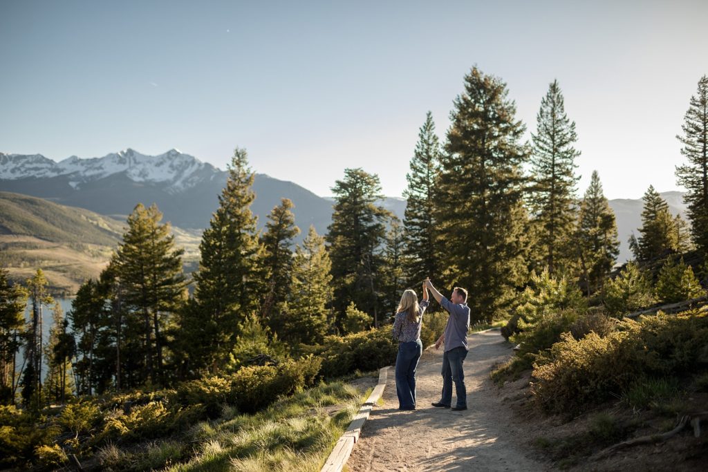 groom and bride to be dance in the mountains during engagement photos