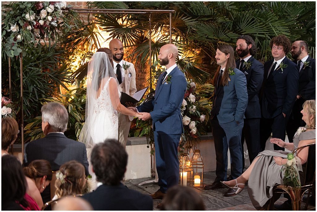 Wedding ceremony at Margaret Place Hotel under arch with floral design by The Plant Gallery in New Orleans