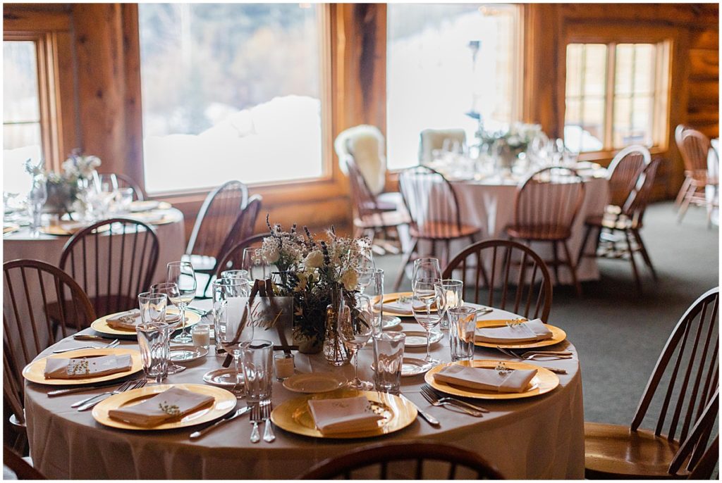 Reception dinner tables at The Pine Creek Cookhouse in Aspen for winter wedding.  Floral decor by Aspen Branch Design.