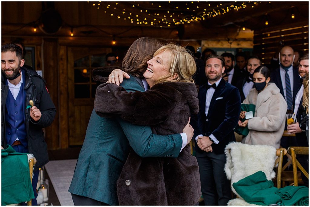Groom and mom walking down the aisle for winter wedding at The Pine Creek Cookhouse in Aspen.