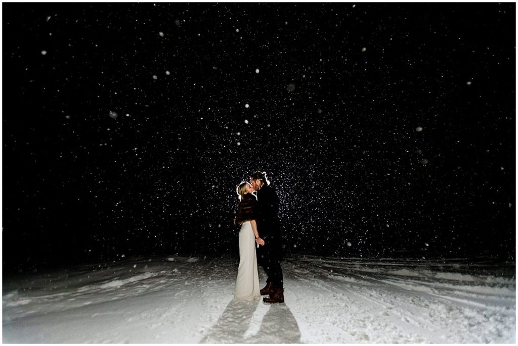 Bride and groom outside at night in the snow at The Pine Creek Cookhouse in Aspen for winter wedding.