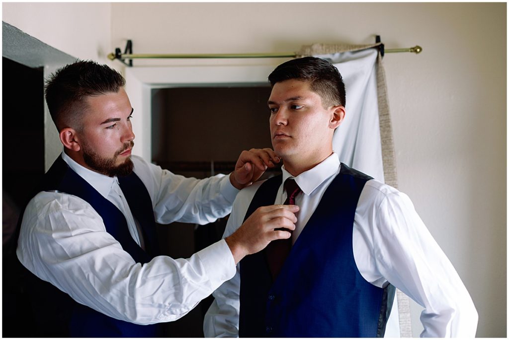 Groom getting ready in Men's Wearhouse suit at Ski Tip Lodge.