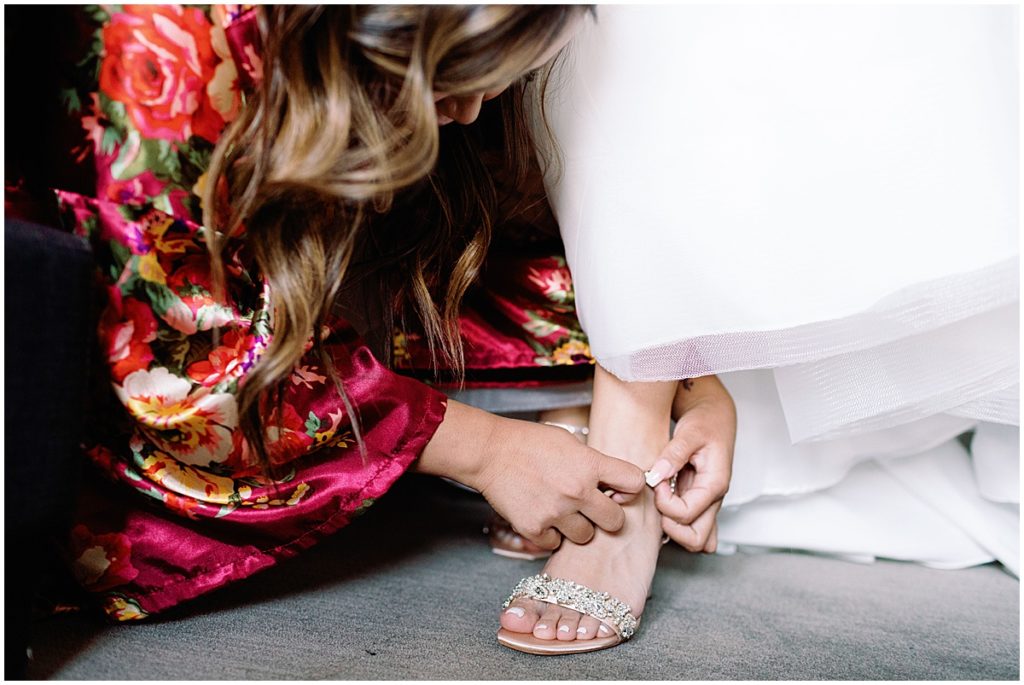 Bride's putting on wedding shoes by Badgley Mischka