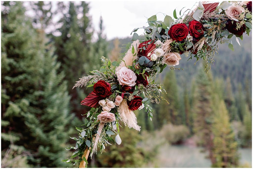 Outdoor wedding floral arch made by Pots & Petals Floral Design at Ski Tip Lodge in Keystone Colorado