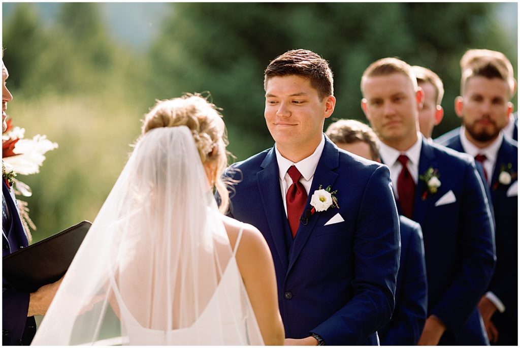 Groom looking at bride at wedding ceremony at Ski Tip Lodge