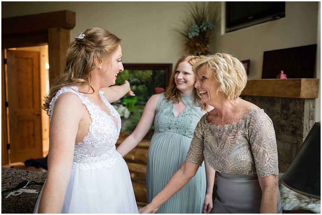 Mother helping daughter put on wedding dress for elopement ceremony at Sapphire Point Breckenridge.