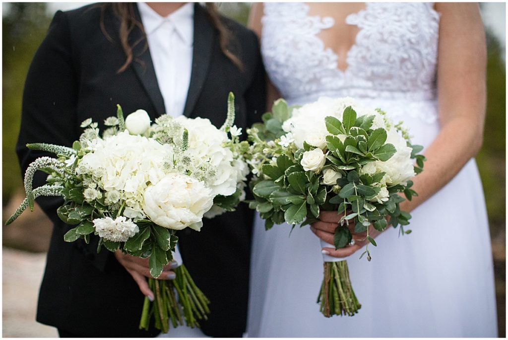 Brides holding bouquets designed by Indigo Flowers for LGBTQ elopement.