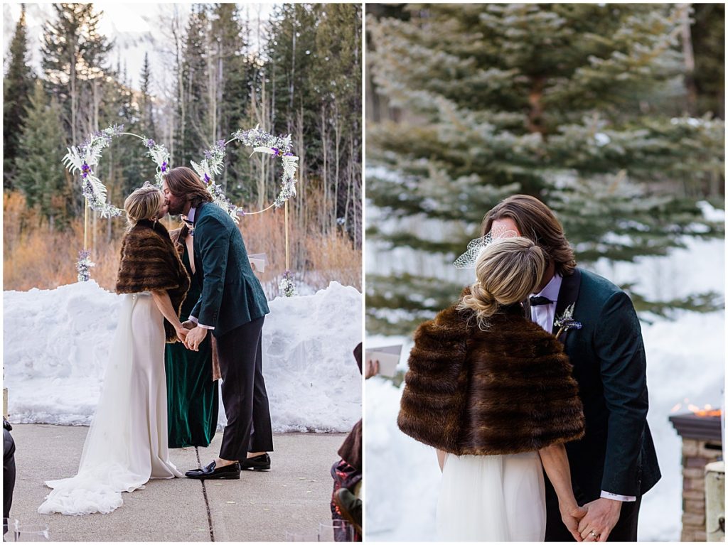 Bride and groom kiss during winter wedding ceremony at The Pine Creek Cookhouse in Aspen