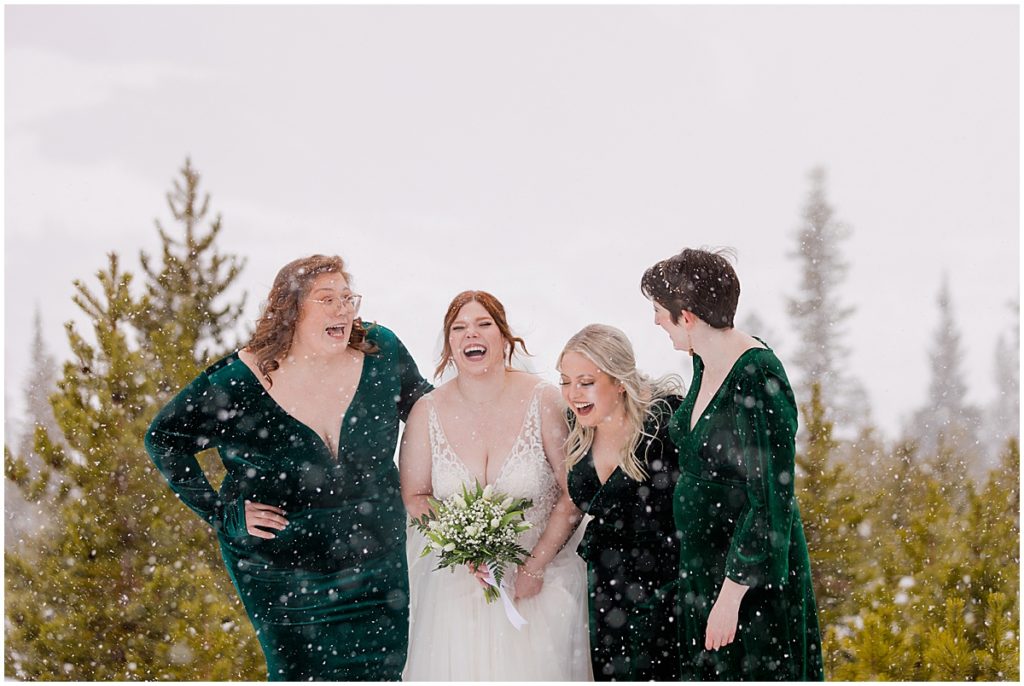 Bride and bridesmaids at Sapphire Point in Breckenridge for a micro wedding ceremony.  Bride is wearing a dress from Champagne and Lace Bridal.  Bride is holding a bouquet designed by Garden of Eden Flowers and Gifts.