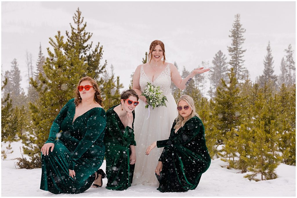 Bride and bridesmaids at Sapphire Point in Breckenridge for a micro wedding ceremony.  Bride is wearing a dress from Champagne and Lace Bridal.  Bride is holding a bouquet designed by Garden of Eden Flowers and Gifts.
