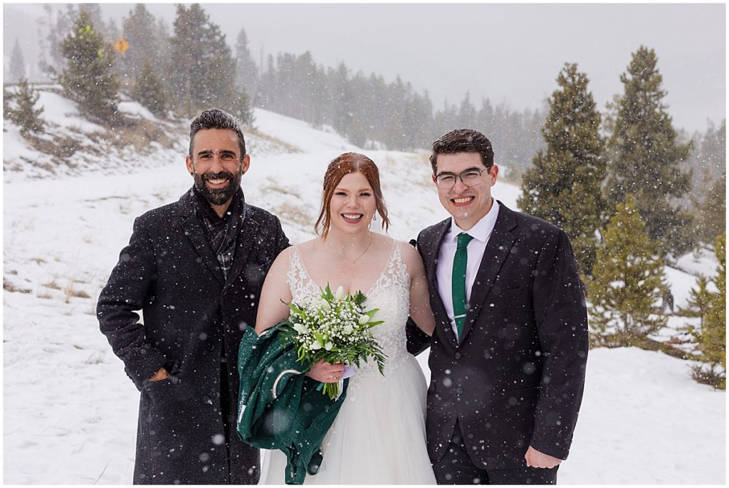 Bride and groom at Sapphire Point in Breckenridge during winter micro wedding ceremony.  Bride is wearing a dress from Champagne and Lace Bridal.  Bride is holding bouquet designed by Garden of Eden Flowers and Gifts.