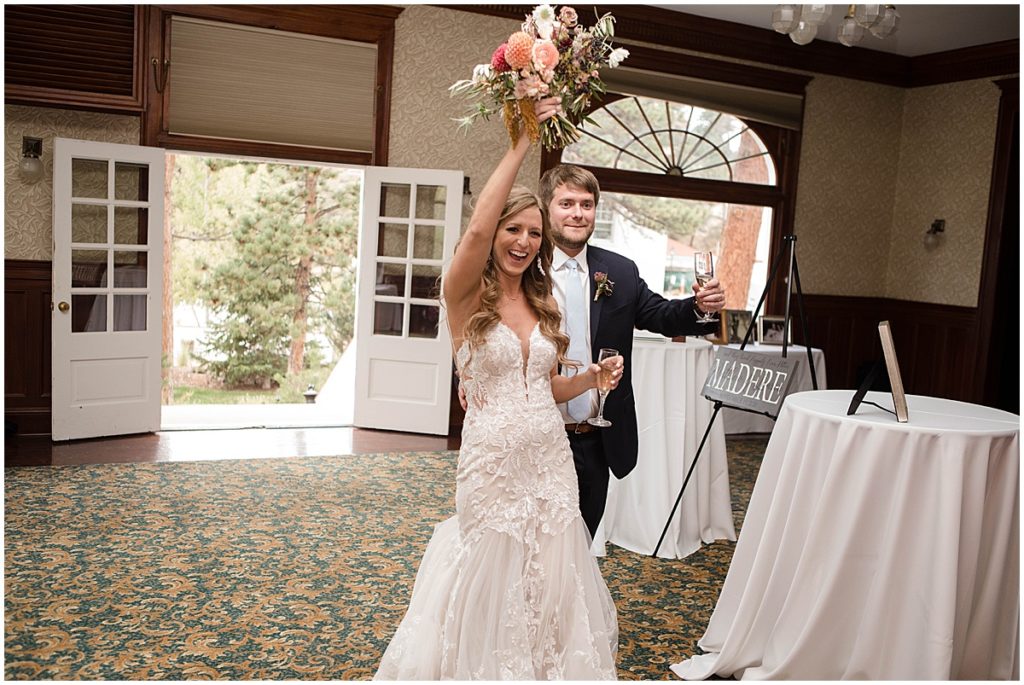 Bride and groom wedding reception at Stanley Hotel in Estes Park.  Bride is wearing dress from Town and Country Bridal holding bouquet from Lace and Lilies Flowers.  Groom wearing suit from Jos A Bank.