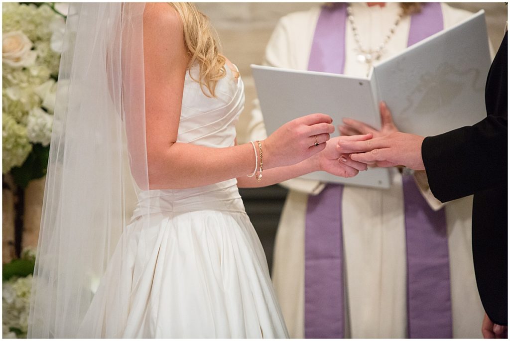 Bride and groom exchanging rings during wedding ceremony at St. Regis hotel in Aspen.