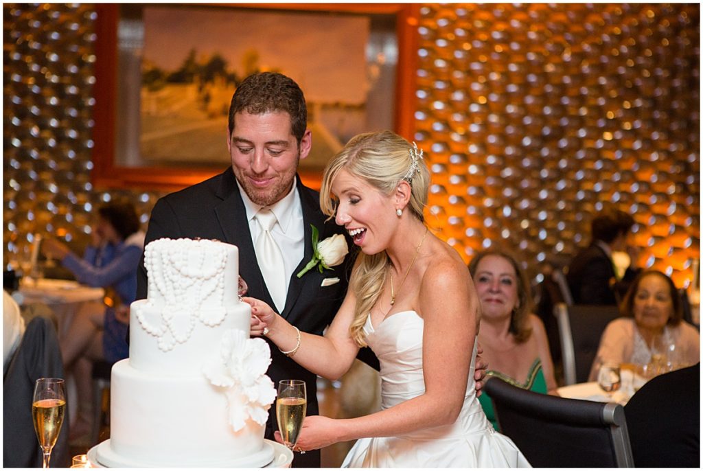 Groom wearing Men's Warehouse suit and bride wearing dress from Bees Bridal cutting cake at St. Regis hotel in Aspen.