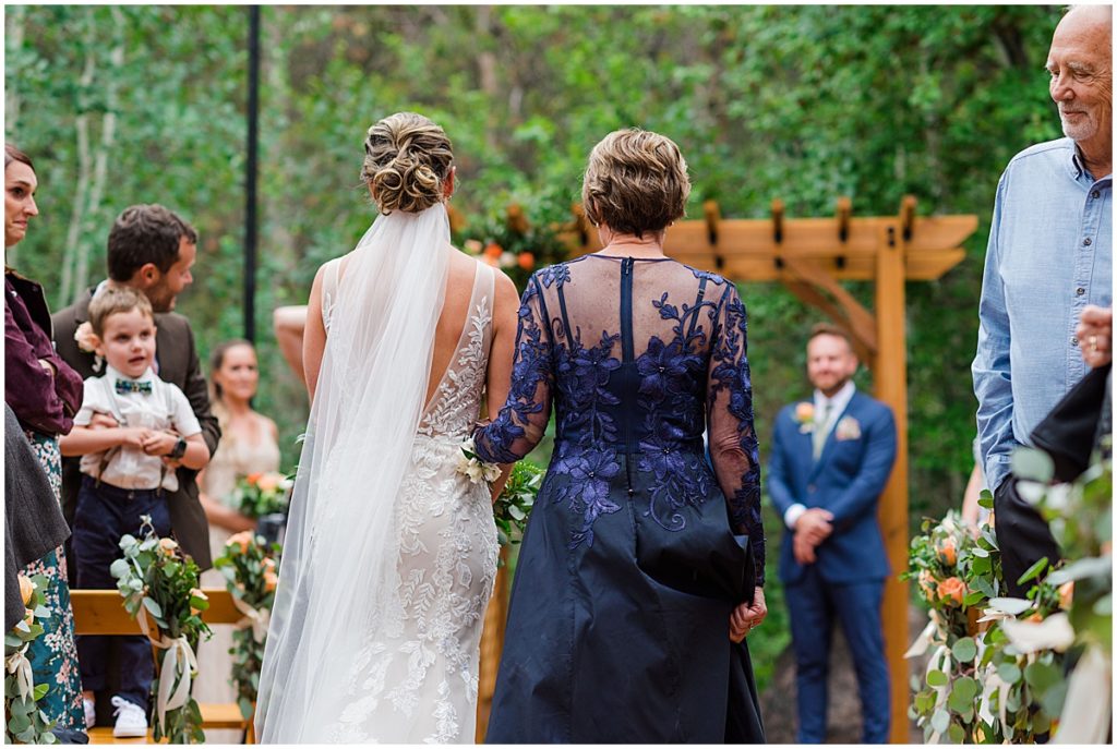 Bride walking down isle wearing Maggie Sottero wedding dress from The Bridal Collection at Donovan Pavilion in Vail.