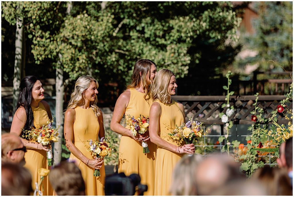Bridesmaid's wearing dress from The Dessy Group at wedding ceremony in Larkspur Vail.  Floral decor by Studio CVB.
