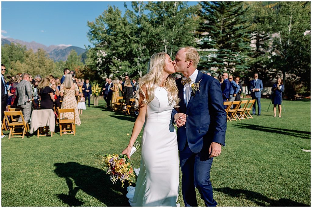 Bride and groom during ceremony at Larkspur Vail.  Floral decor by CVB Studio.  Bride is wearing dress from Annika Bridal and groom wearing suit from The Suit Shop.