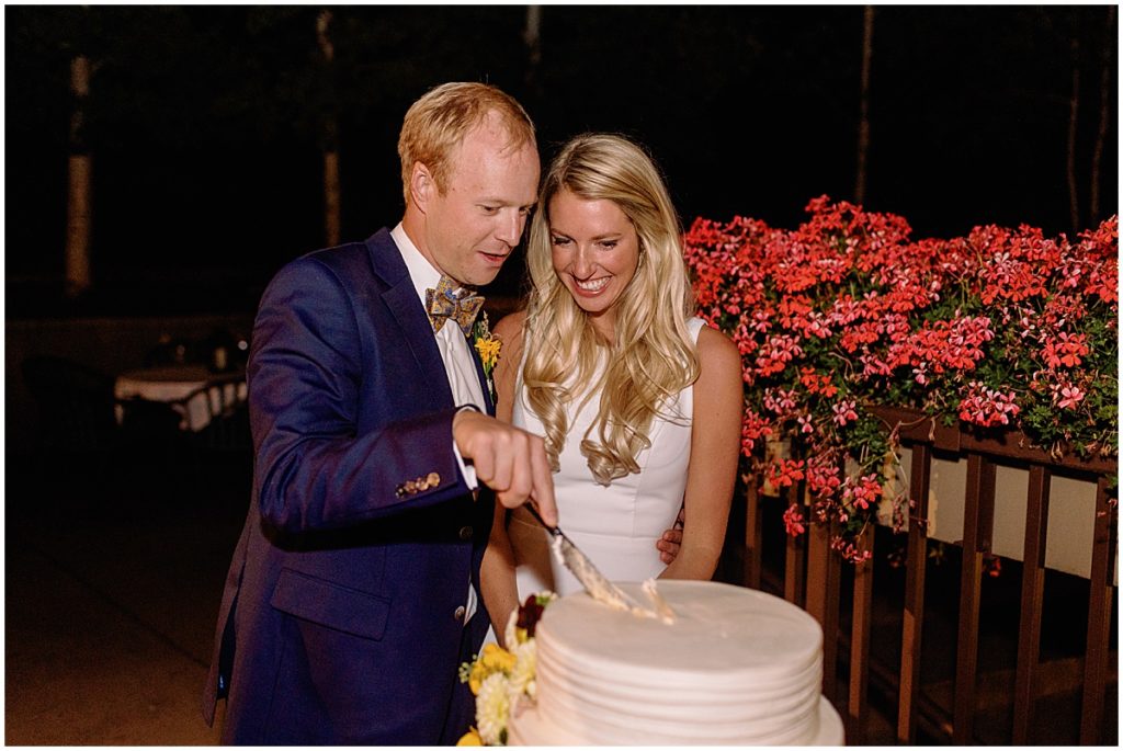 Bride and groom cutting wedding cake during reception at Larkspur Vail.