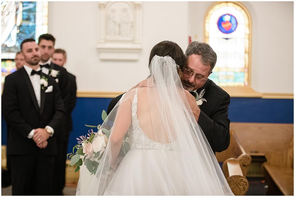Bride walking down aisle with dad for wedding ceremony at Sacred Heart of Mary Catholic Church in Boulder.