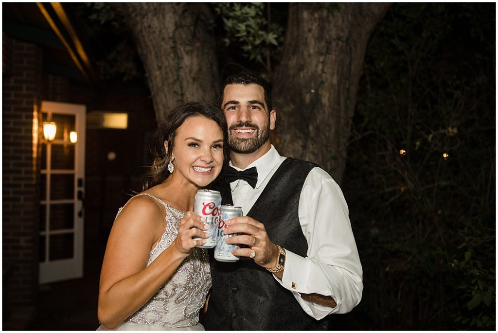 Bride and groom outside of Lionsgate in Louisville holding Coors Light.