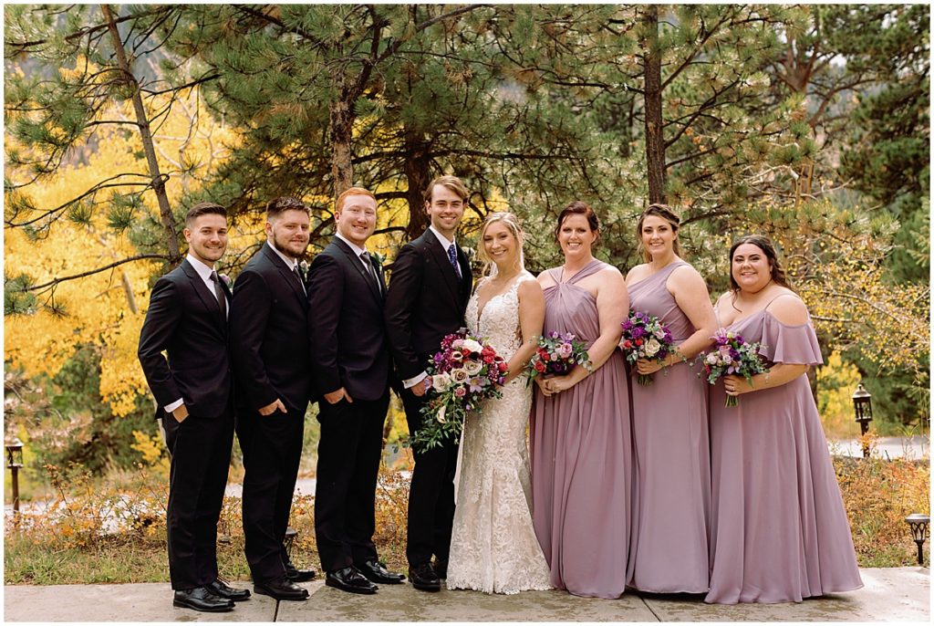 Bridal party at Della Terra Mountain Chateau in Estes Park.  Bride wearing wedding dress designed by Martina Liana from Volle's Bridal & Boutique.  Groom Wearing suit from Men's Wearhouse.  Bride holding bouquet from The Perfect Petal.