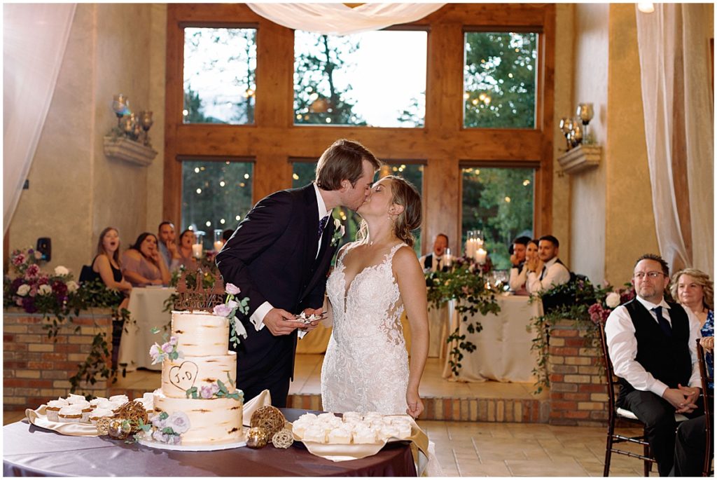 Bride and groom cutting wedding cate at Della Terra Mountain Chateau in Estes Park.  Cake designed by The Makery.  Bride wearing wedding dress designed by Martina Liana from Volle's Bridal & Boutique.  Groom Wearing suit from Men's Wearhouse. 