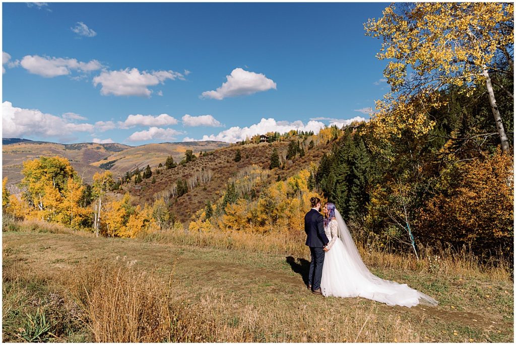 Bride and groom holding hands during first look before ceremony in Beaver Creek.  