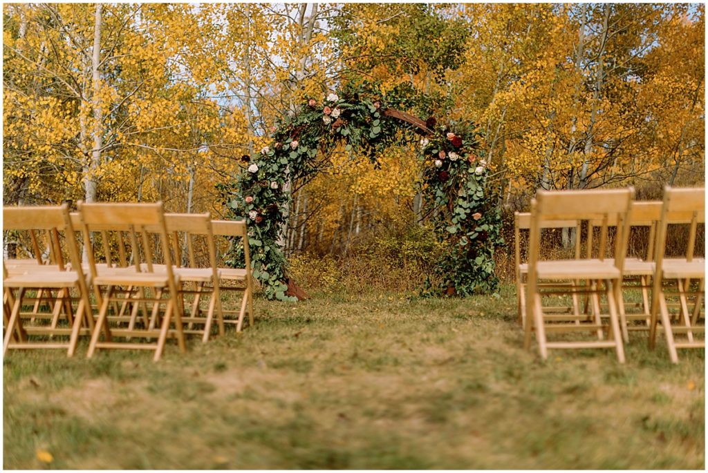 Guest seating outside at Anderson's cabin in Beaver Creek. Floral arch designed by Bloom Flower Shop.