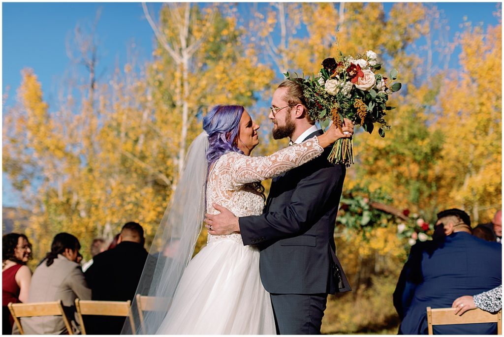 Bride and groom hugging after  wedding ceremony at Anderson's Cabin in Beaver Creek.