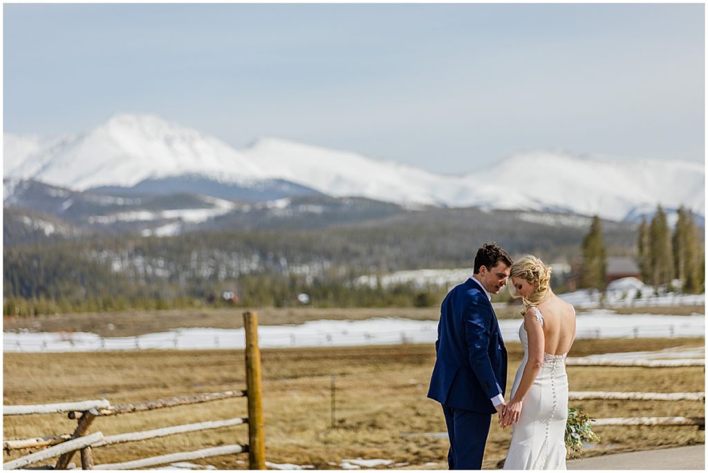 Bride and groom first look outside at Devil's Thumb Ranch with snow covered mountains.