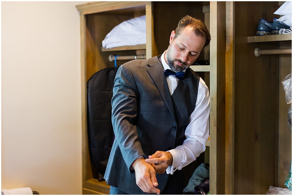 Groom getting suit on from Men's Warehouse for wedding at The Vineyards and Chappel Lodge wearing.