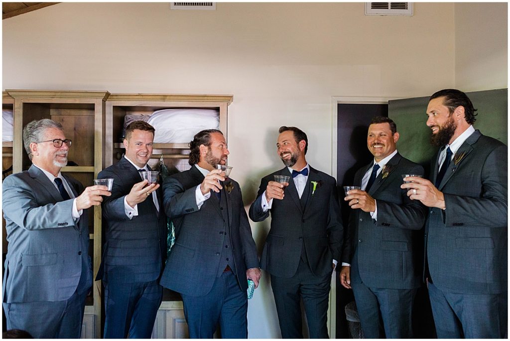 Groomsmen celebrating with toast.  Groom wearing suit from Men's Wearhouse.